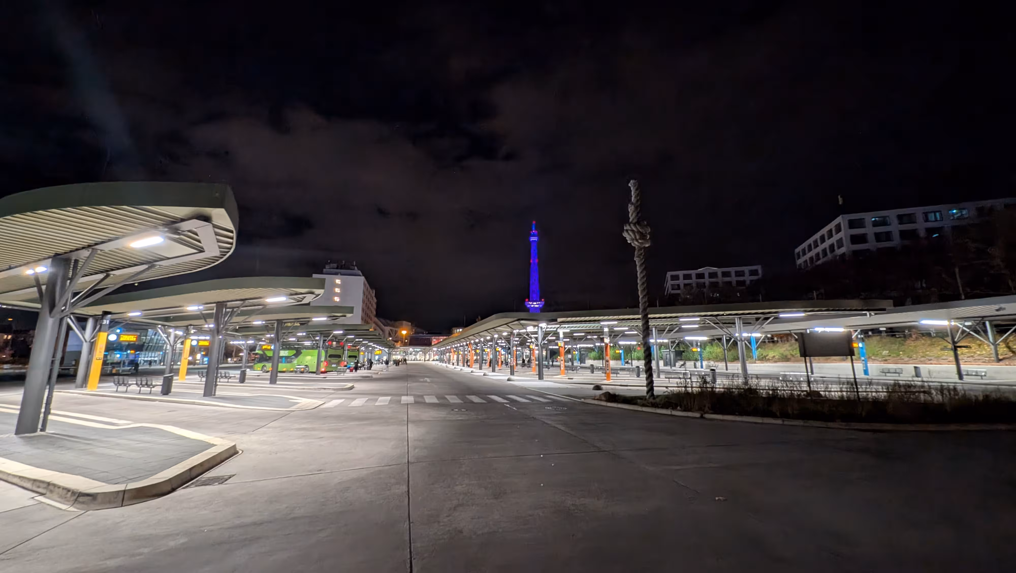 Die beleuchteten ZOB-Haltestellen bei Nacht mit Blick auf den blau angestrahlten Funkturm